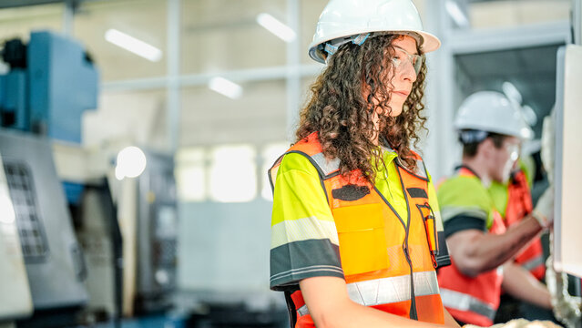 Mechanical production operator executing industrial machinery maintenance protocols. Skilled female worker inspecting manufacturing quality standards.