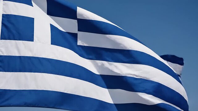 Greek flag waving proudly against a clear blue sky