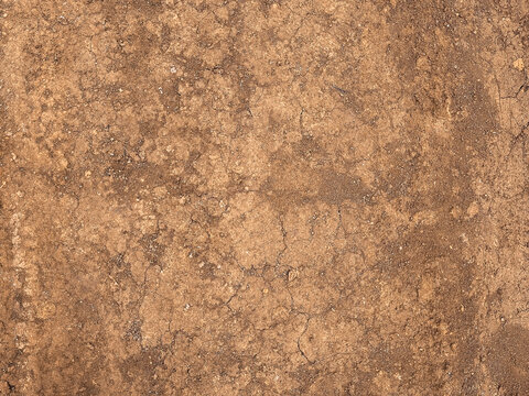 Organic brown dirtied earth ground texture background of dry land surface with natural cracks. Soil Texture