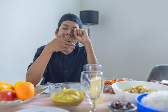 Sleepy Muslim Man Yawning And Rubbing Eyes While Waiting For Iftar Fasting Break
