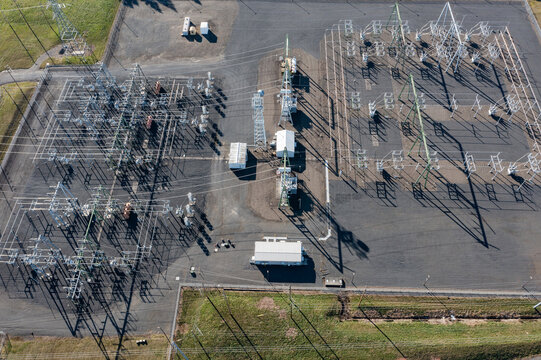Aerial drone picture of large electric power substation and high voltage power lines in Beaverton, Oregon, showing transmission towers, transformers, and distribution infrastructure from above	
