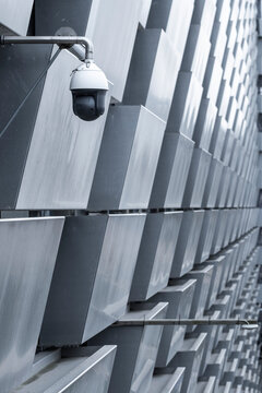 Urban modern architecture of building facade with diagonal windows pattern and mounted security camera creating graphic perspective