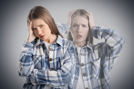 Worried young woman on grey background