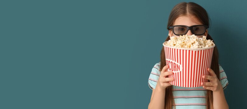 Little girl in 3D glasses and with popcorn on blue background with space for text