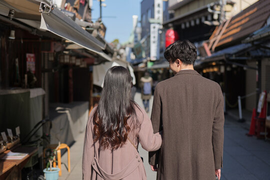 柴又の観光地を腕を組んで歩くカップルの後ろ姿