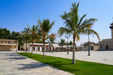 Fototapeta premium Modern landscaped plaza with palm trees in the historic district of Yanbu, Saudi Arabia