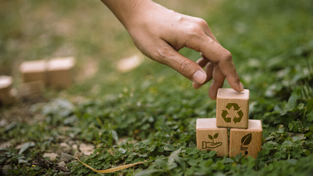 Hand Stacking Recycling and Green Energy Wooden Blocks on Nature Background, Sustainable Business Strategy Concept