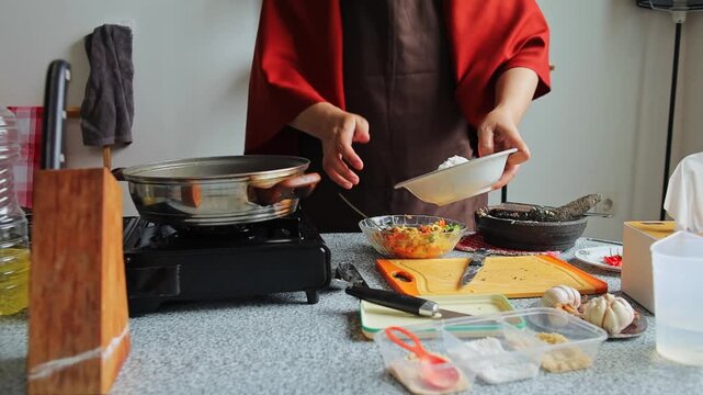 Hands adding ingredients to bowl to prepare traditional corn fritters
