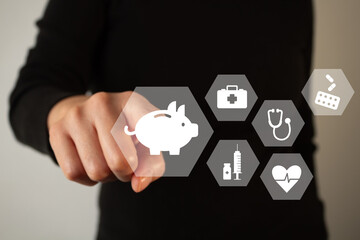Health insurance savings. A person's hand points to a piggy bank icon surrounded by medical-related...