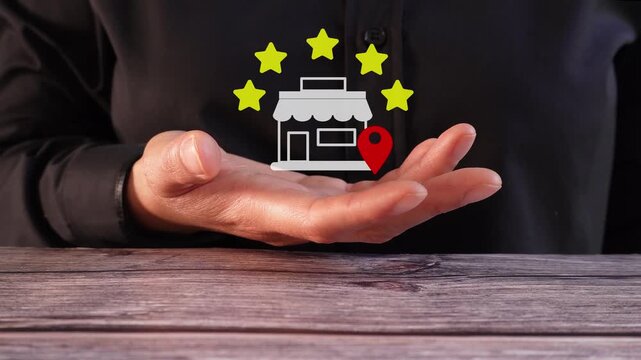 Close-up of a woman's hand on a table holding an animated five-star rating for a local store.