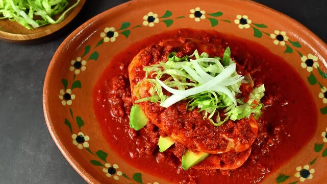 Mexican pambazo with red sauce and avocado, top view