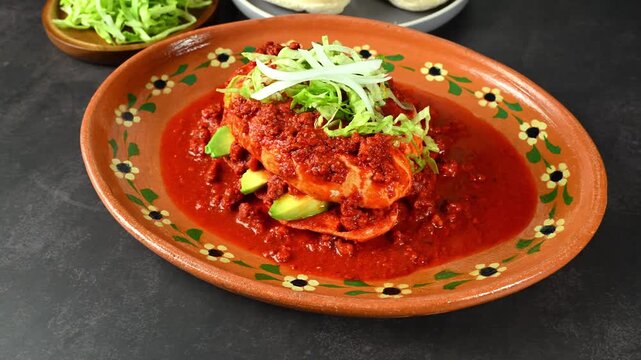 Traditional Mexican pambazo or chancla poblana with red guajillo sauce and chopped meat