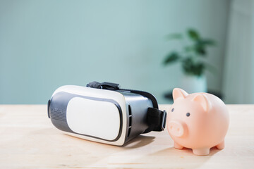 pink piggy bank for money, metaverse banking, casino vr and ar saving concept features technology, virtual reality headset on wooden desk for digital finance and global investment