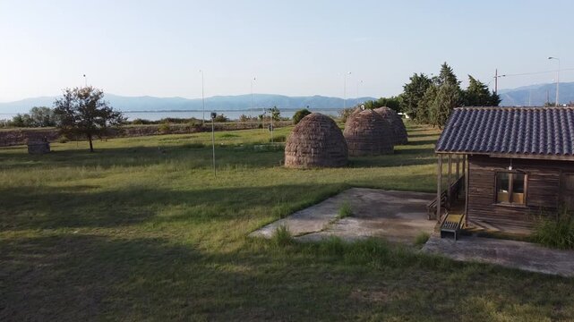 Cinematic drone orbit around traditional Sarakatsani huts in Porto Lagos, Xanthi, showcasing authentic nomadic architecture and the cultural heritage of Thrace in northern Greece.