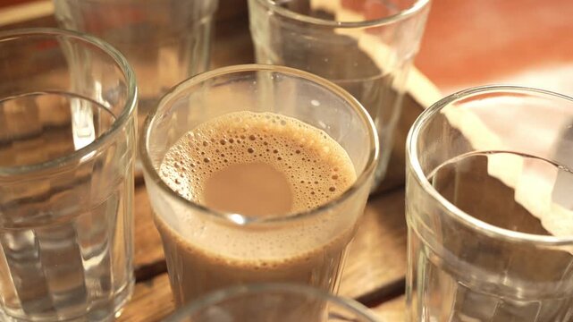 Indian chai served in glass cups, brewed in a metal kettle with aromatic masalas.