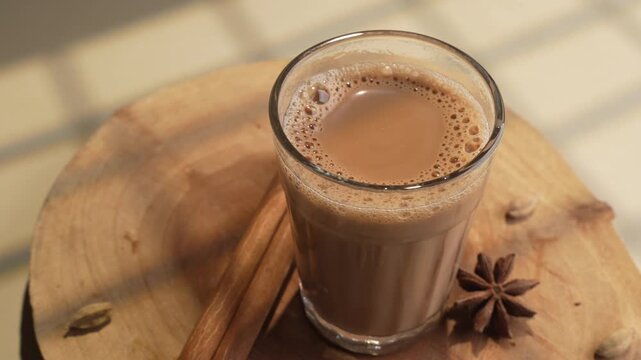 Indian chai served in glass cups, brewed in a metal kettle with aromatic masalas.