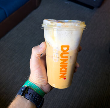 Iced Latte from Dunkin Held in Hand Indoors