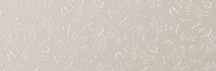 A subtle white embossed floral pattern with delicate leaves and blossoms creating an elegant textured wallpaper background.