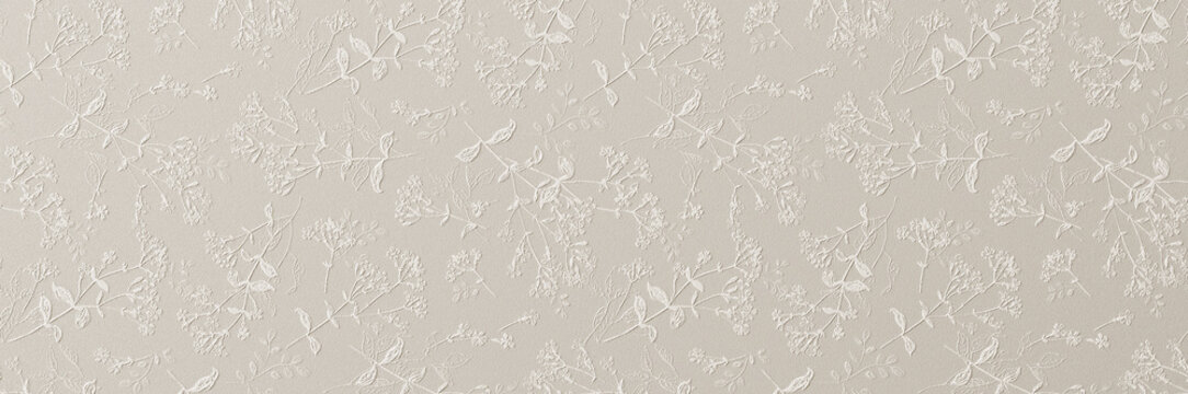 A subtle white embossed floral pattern with delicate leaves and blossoms creating an elegant textured wallpaper background.