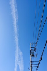 飛行機雲と青空と電信柱