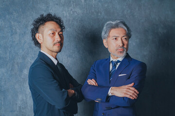 腕組みをするスーツ姿の男性