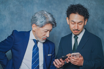 スマートフォンを操作するスーツ姿の男性