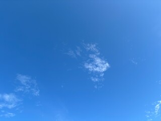 Obraz premium Clear blue sky with small white clouds and copy space