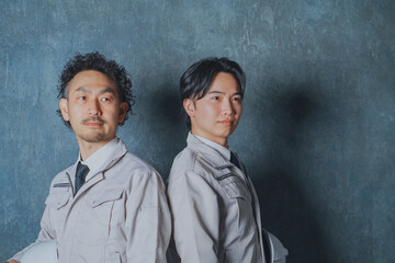 ヘルメットを持った作業着姿の男性