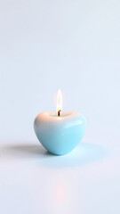 Lit Blue Heart-Shaped Candle on Light Background