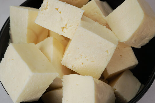 Paneer cottage cheese close up, slice pieces of homemade fresh white raw paneer cheese.