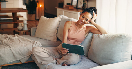Obraz premium Happy, woman and relax on couch with tablet, watch social media video and entertainment on weekend. Female person, smile or peace in home with tech, digital app or streaming website for online movie.