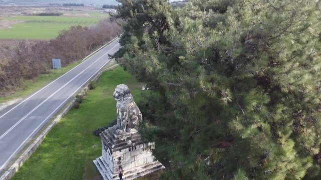 Cinematic drone orbit shot of the 4th-century BC Lion of Amphipolis. A 180-degree view of the iconic marble monument, symbolizing Macedonian military valor and ancient Greek history.