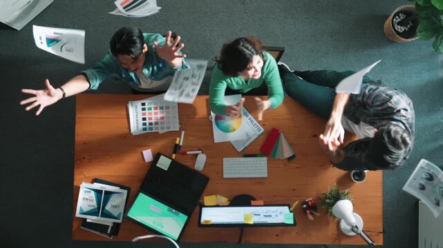 Top view of smart business team hands looking at color palette at table while throw paper in the air. Group of interior design talking and discussing about successful idea and celebrating. Symposium.