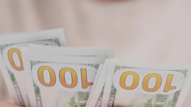 Close up of female hands recounting US dollars. Financial planning, expense control and money management theme.