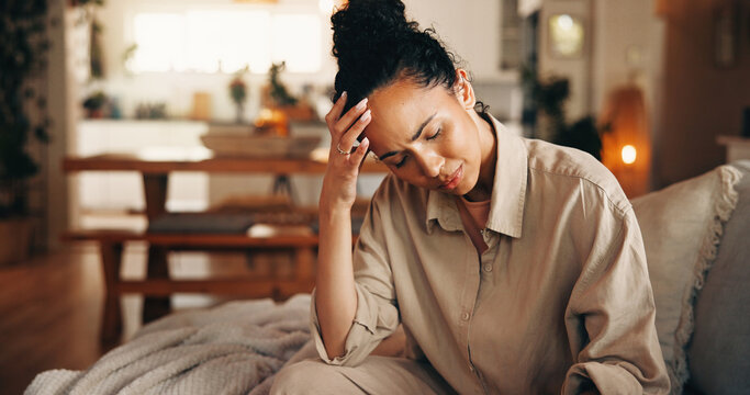 Couch, headache and woman in home with pain, stress and bankruptcy with debt in living room. Brain fog, sick and person with migraine, mental fatigue or overwhelmed with financial crisis in house