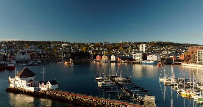 Drone view of boats in the marina and waterfront buildings in Tromso, Norway. Aerial ascending, Copy space