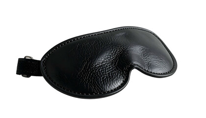 Close-up of a black leather eye mask with an adjustable strap, isolated on black