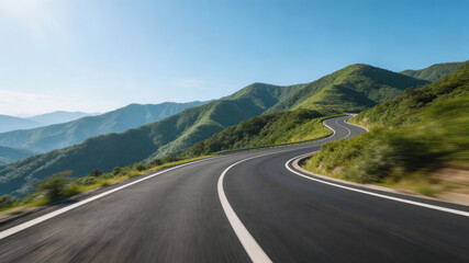 Naklejka premium A smooth, curved road traverses lush green mountains under a clear blue sky, ideal for scenic driving and travel adventures through natural landscapes.