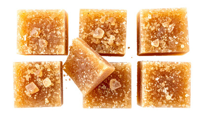 Close-up of six brown sugar cubes with some crystals, one tilted slightly