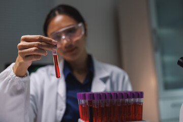 Scientist holding test tube doing blood analysis research © Phimwilai