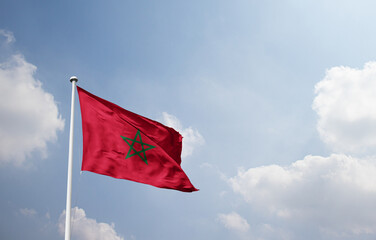 Morocco national flag waving in sky.