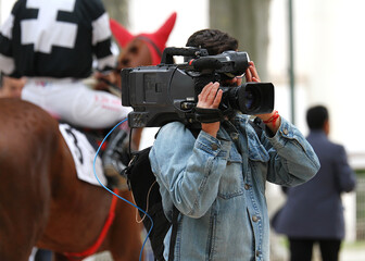 Camar&oacute;grafo vide&oacute;grafo grabando directo con c&aacute;mara al hombro en hip&oacute;dromo