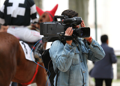 Camar&oacute;grafo vide&oacute;grafo grabando directo con c&aacute;mara al hombro en hip&oacute;dromo