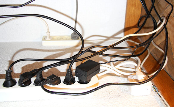 Cables de electricidad enredados y enchufados a ladr&oacute;n y corriente el&eacute;ctrica con multiconector de red y regleta