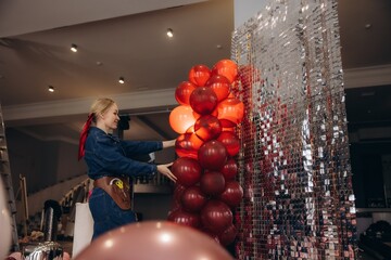Event coordinator decorating party photo zone with balloons