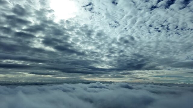 Immersive aerial view taken from a jet cockpit flying between endlless layers of ethereal clouds, with a faded sun veiled above. hyperlapse x4