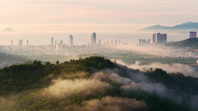 Drone view clouds drifting through mountain peak, far away is Nha Trang city