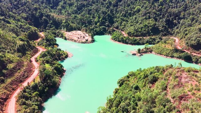 In Lam Dong, Vietnam, the clear green water attracts visitors. People explore the area by the lake and enjoy the beauty of nature and the fresh air while surrounded by hills.