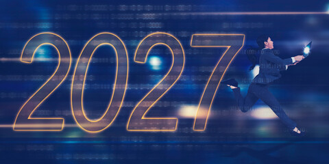 Businesswoman Jumping Towards 2027 with Laptop on Digital Tech Background