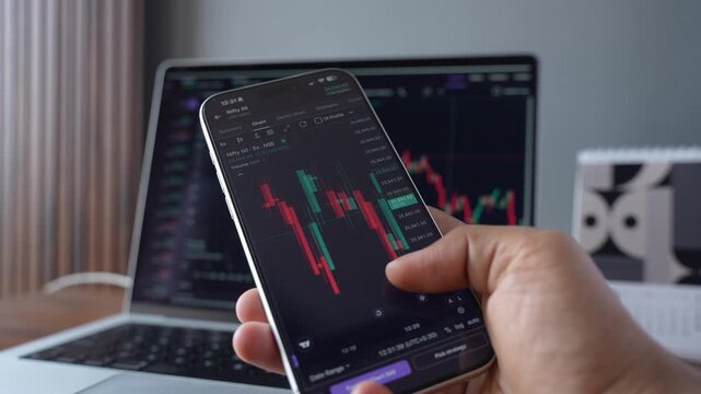 Stock Exchange Broker Analyzing Real-Time Stocks and Exchange Market Charts on Smartphone Using Online Trading App. Investment Agent Working in Office. Close Up.